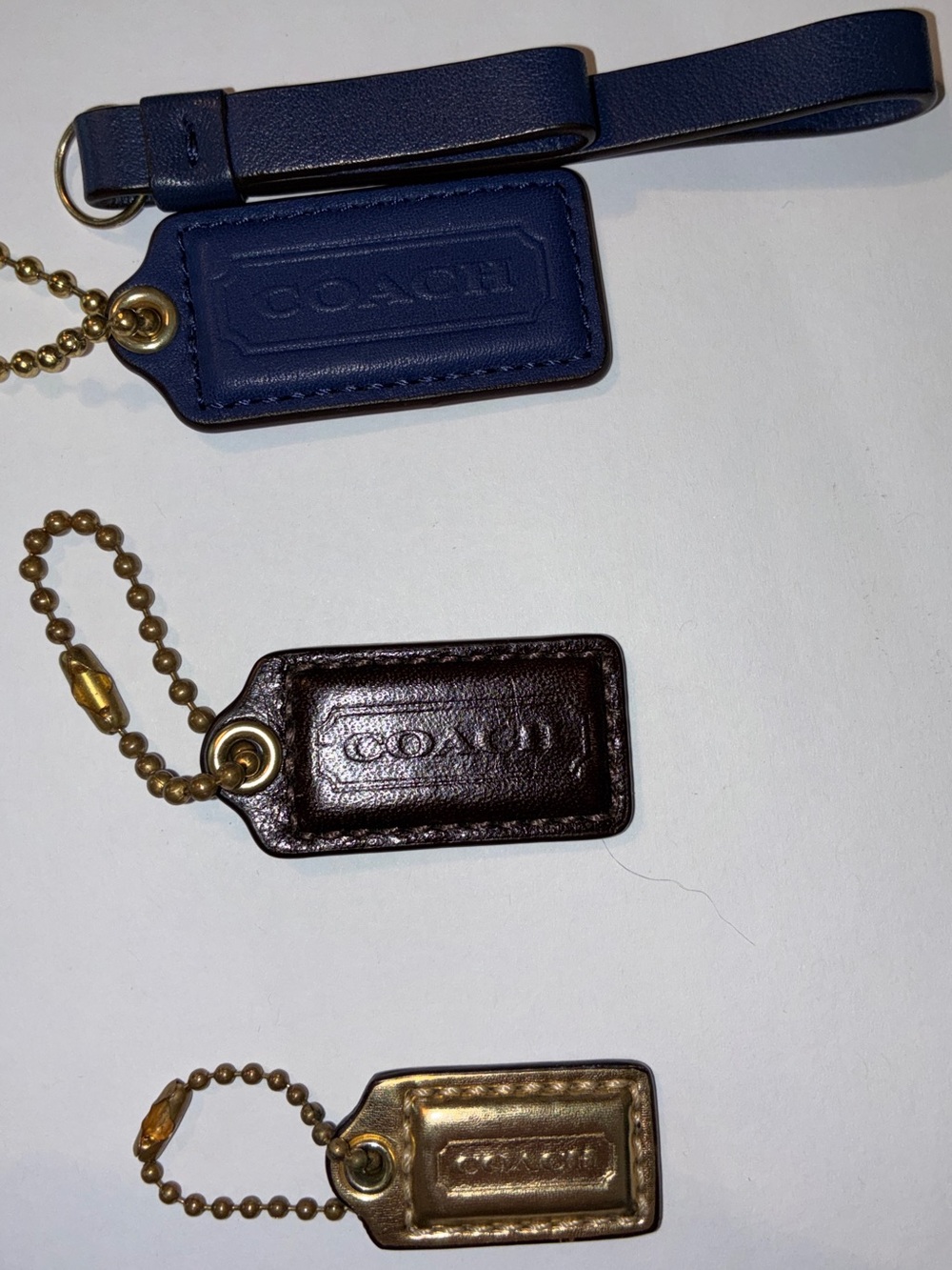 3 Coach hang tags - 1 set blue with pull strap, 1 patent brown, 1 gold